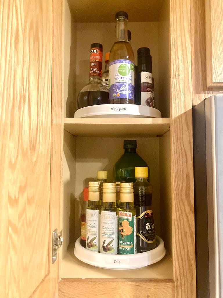 An organized cupboard with oils on a lazy susan