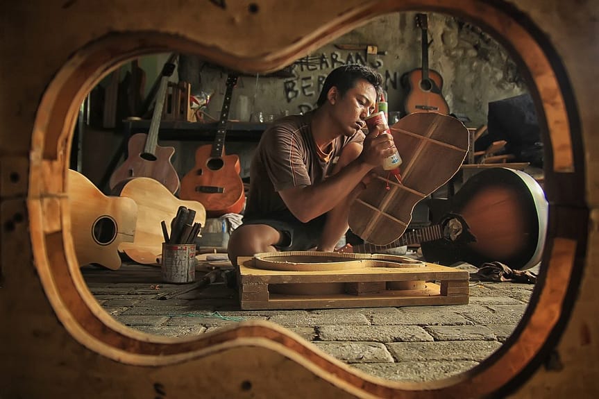 man making and designing guitar