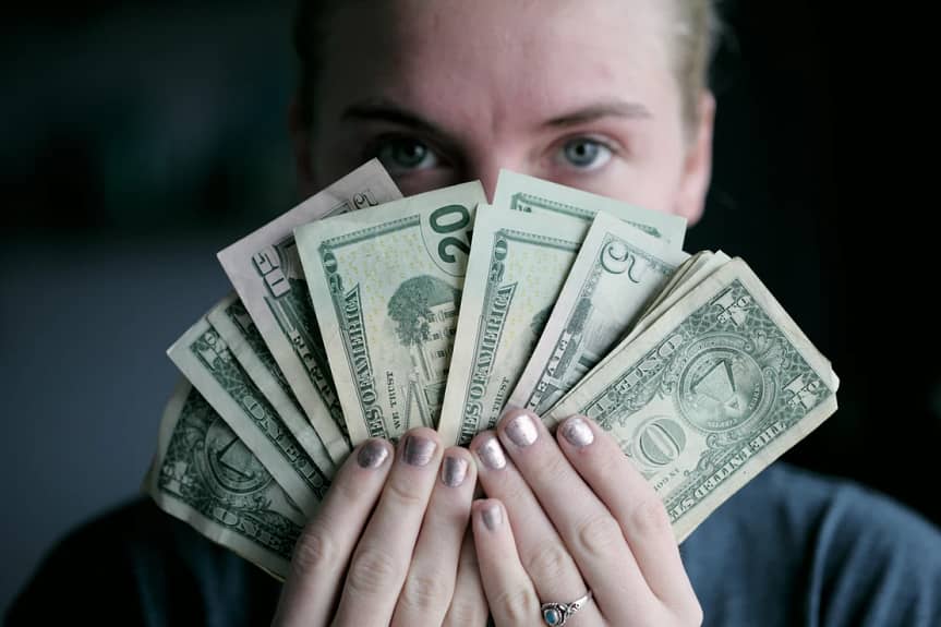 Woman holding up money made in Scottsdale and phoenix Arizona