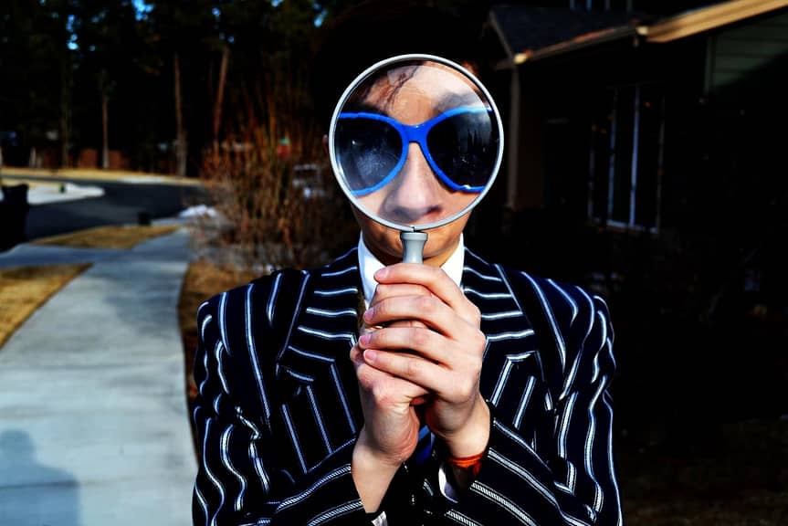 person using magnifying glass to identify her availability heuristic